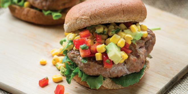 turkey burgers stacked tall with avocado, corn, and peppers