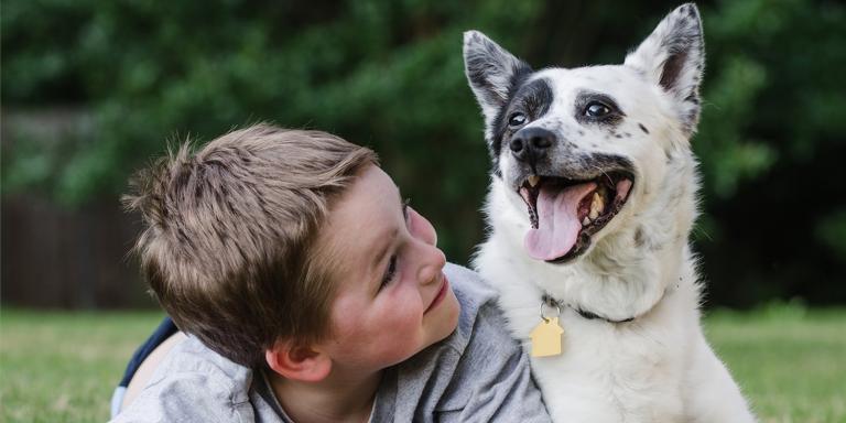 a boy smiling with his healthy dog